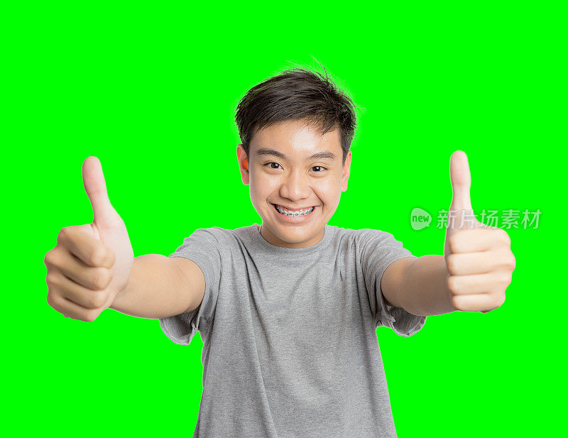 快乐的年轻人竖起大拇指，成功的手势微笑着，快乐着。英俊的年轻人，多种族的亚洲/高加索模型隔离在绿色屏幕上色度关键背景。